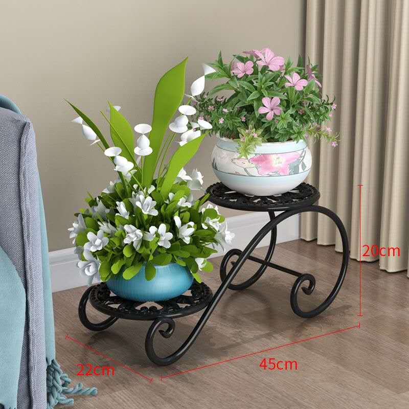 A two-tiered plant stand in white and black, with various plants and flowers placed on it, measuring 22x45xx20 cm.