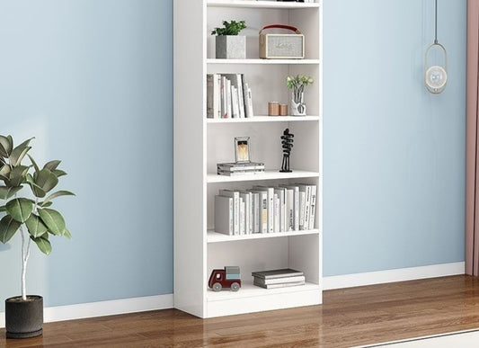 A white bookshelf with multiple shelves, placed against a blue wall in a room with a plant and decorative items on the shelves.
