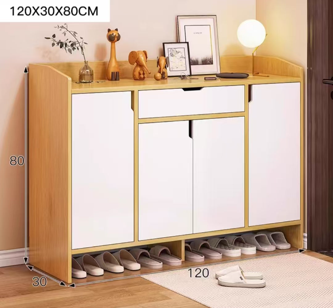 A brown and white shoe cabinet with multiple compartments, storing various shoes, placed in a room with decorative items on top.