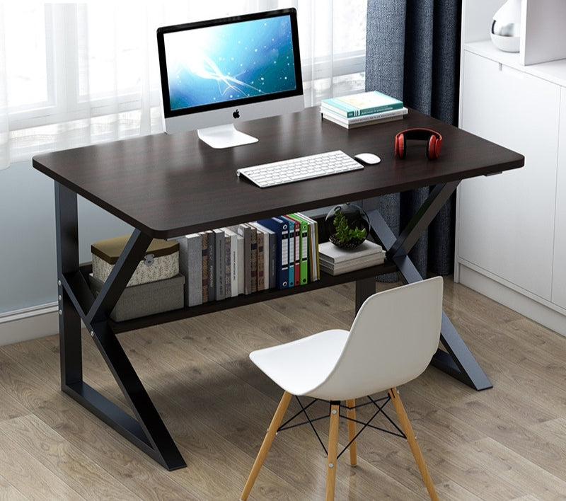 A study desk with a dark walnut top and black steel frame, accompanied by a white chair and various items such as a monitor, keyboard, and books.